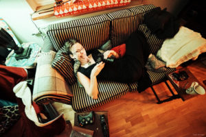 A wide angle shot of Courtnee spreading out on a two-seater couch